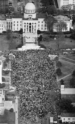 Civil rights marchers form a crowd in front of the Alabama State Capitol on March 25, 1965, in Montgomery, Ala., at the end of their five-day march from Selma, Ala., to protest discrimination against African-Americans in the state's voting practices. A line of guards stretches across the Capitol steps, upper center, but no attempt was made by marchers to enter the Capitol. [Bill Achatz/The Associated Press]