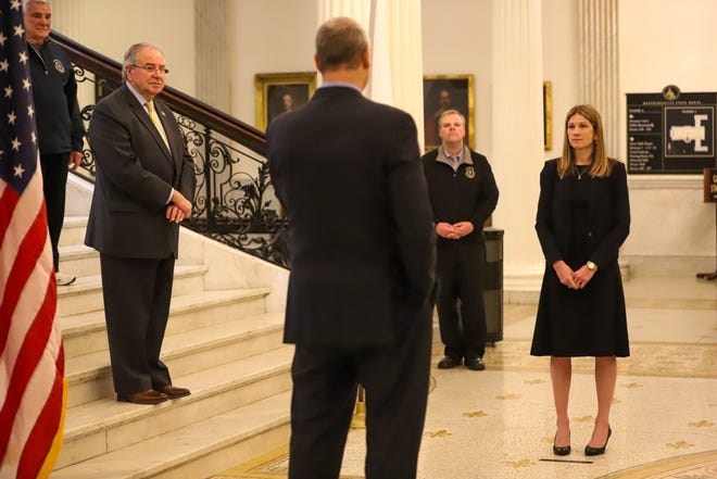 Rep. Kate Lipper-Garabedian, right, was sworn in by Gov. Charlie Baker at the foot of the Grand Staircase on Wednesday, a quiet ceremony attended by a few lawmakers and staff while the State House is mostly closed due to the coroinavirus emergency. [State House News Service Photo / Sam Doran]