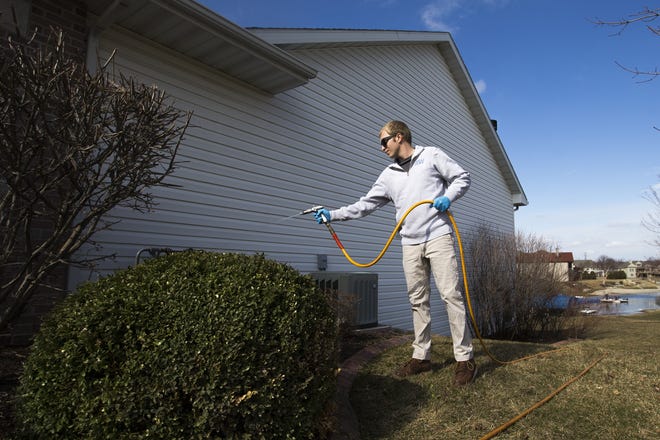 Zach Patnou, co-owner of Midwest Pest Control, applies a pest control treatment at a residence on Key West Drive in Machesney Park on Wednesday. [SCOTT P. YATES/RRSTAR.COM STAFF]