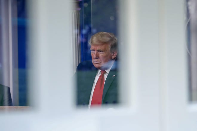 Seen through a window, President Donald Trump speaks about the coronavirus pandemic Thursday in the James Brady Briefing Room in Washington. [Alex Brandon/The Associated Press]