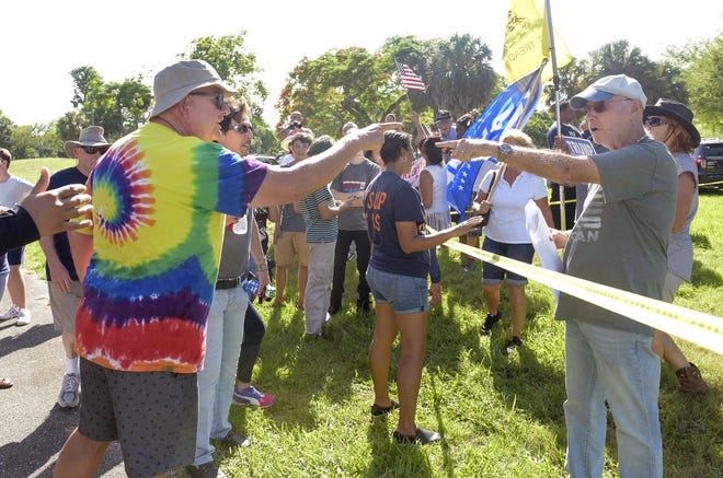 A.J. Wasson (left) and Mel Grossman, president of the Palm Beach Tea Party disagree on Trump policies before a rally Friday, June 22, 2018. (Melanie Bell / The Palm Beach Post)
