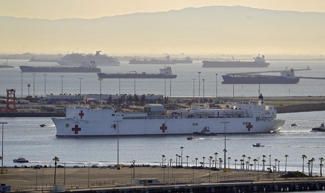 The USNS Mercy enters the Port of Los Angeles on Friday in Los Angeles. The 1,000-bed Navy hospital ship is expected to help take the load off Los Angeles-area hospitals as they treat coronavirus patients. California hit 4,700 cases of the coronavirus Friday, with at least 94 deaths. [MARCH J. TERRILL/AP]