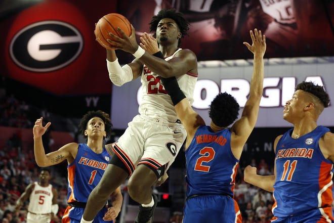 Georgia's Rayshaun Hammonds (20) shoots while being defended by Florida guard Andrew Nembhard (2) in Athens on March 4. Florida won 68-54. [JOSHUA L. JONES/ATHENS BANNER-HERALD]