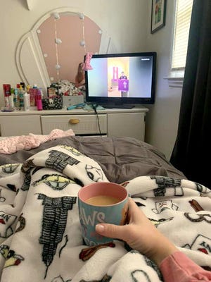 Catherine Lilly of Shelby holds a cup of coffee on March 22 while watching the live stream of a service from Ascension Lutheran Church. [Special to The Star]