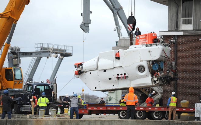 The research sub Alvin is lowered by crane onto a flatbed truck Monday for transport to a Woods Hole Oceanographic Institution shop where it will undergo an $8 million upgrade that will allow it to explore greater ocean depths. [Merrily Cassidy/Cape Cod Times]