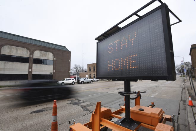 A sign encourages the public to stay at home and stay safe during the coronavirus outbreak Friday, March 27, in downtown St. Joseph, Mich. As of Monday, March 30, there are 6,498 confirmed COVID-19 cases in Michigan. (Don Campbell/The Herald-Palladium via AP)