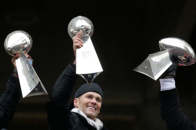 FILE - In this Feb. 7, 2017, file photo, New England Patriots quarterback Tom Brady holds a Super Bowl trophy beside others the team previously had won during a rally in Boston to celebrate the team's 34-28 win over the Atlanta Falcons in the NFL Super Bowl 51 football game in Houston. If Tom Brady isn't a unanimous selection to the All-Decade team, it will be a bigger upset than the Jets over the Colts in Super Bowl 3. Next Monday, April 6, 2020, the Hall of Fame and the NFL will announce the roster for the 2010-19 span. (AP Photo/Elise Amendola, File)