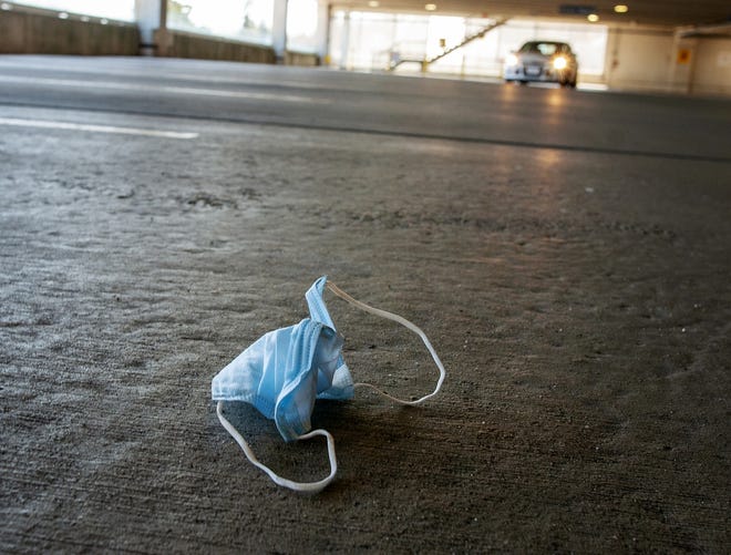 A medical face mask is discarded in a nearly empty parking garage at UMass Memorial Medical Center - University Campus in Worcester on Friday. [T&G Staff/Rick Cinclair]