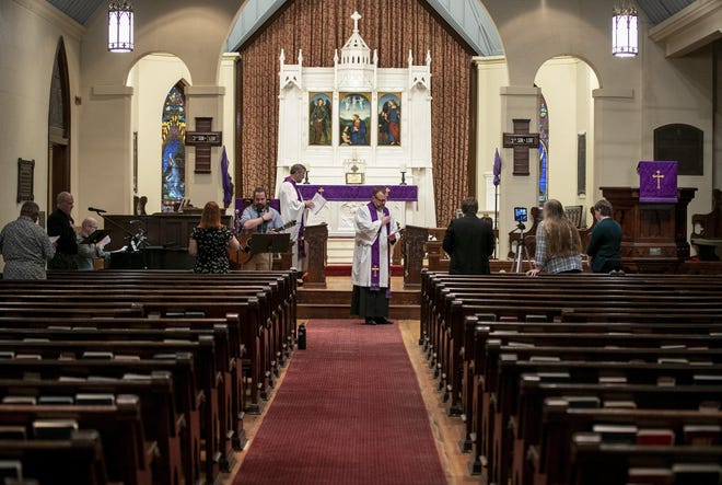 The Rev. Chuck Treadwell, left, and the Rev. Chad McCall lead a worship service in a near-empty sanctuary at St. David’s Episcopal Church in downtown Austin on March 15. Due to the coronavirus outbreak, the congregation’s 2,000 members were asked to stay home and watch the service streamed live on the church’s Facebook page. [JAY JANNER/AMERICAN-STATESMAN]