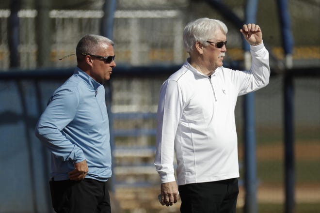 Kansas City Royals general manager Dayton Moore, left, and owner John Sherman watch a drill during spring training baseball practice Feb. 19 in Surprise, Ariz. [Charlie Riedel/The Associated Press]
