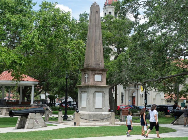 People walk past the Confederate Memorial on the Plaza de la Constitucion in St. Augustine. Public spaces like the Plaza are still open in the city, but gatherings of more than 10 are not allowed. [PETER WILLOTT/THE RECORD]