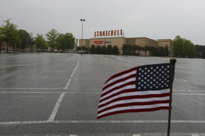 March 31, 2020 Stonecrest: A small American flag waves at the edge of an the empty parking lot outside The Mall at Stonecrest and New Vision Theatre during the coronavirus pandemic on Tuesday, March 31, 2020, in Stonecrest.  Curtis Compton ccompton@ajc.com