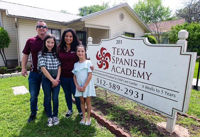 Matthew and Edina Morrison, and their two daughters, Madeline and Chloe, stand outside the Texas Spanish Academy in downtown Round Rock. The academy remains closed to keep students safe during the coronavirus pandemic. [PHOTO BY ARIANA GARCIA]