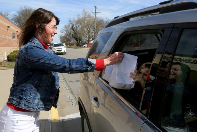 Unified School District 313 assistant superintendent Cindy Couchman hands bags of breakfast food to Maria Harder and family Wednesday morning at Buhler High School. Couchman will become superintendent July 1 after her mentor, Mike Berblinger, retires from the school district. [Sandra J. Milburn/HutchNews]