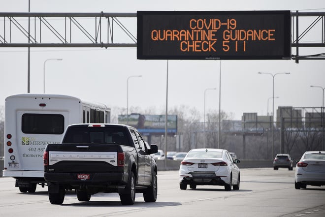 A road sign over Interstate 80 in Omaha, Neb., directs motorists to contact 511 for Covid-19 quarantine guidance, Tuesday, March 31, 2020. Travelers coming back to Nebraska from out of state are advised to self-quarantine for 14 days. This includes snowbirds returning to Nebraska after having spent the winter in places like Arizona, Florida, or Texas, or those visiting secondary residences within Nebraska. However, the guidance to self-quarantine does not apply to commuters or workers in the transportation industry. (AP Photo/Nati Harnik)