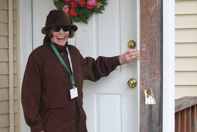 Linda Larson smiles while ringing a doorbell to deliver supplies with Volunteer Community Services of Woodward and Granger. PHOTO BY ANDREW BROWN/DALLAS COUNTY NEWS