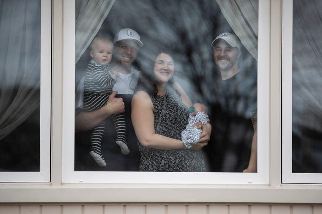 Trevor and Jennifer Thompson with their sons Mack, 1, Hollis, 3 days, and Tim Vigus, 24, pose for a photo at the their home in Warren, Tuesday, March 31, 2020. [JUNFU HAN, DETROIT FREE PRESS]