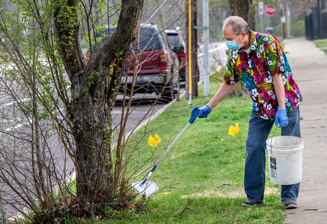 Tim Herold picks up a piece of garbage Wednesday, April 8, 2020 along NE Monroe Street in Peoria. Herold typically collects trash along a two-mile route a couple of days a week. With extra time on his hands because of COVID-19 restrictions, Herold has stepped up his efforts to about five miles a day. [MATT DAYHOFF/JOURNAL STAR]