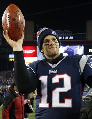 In this Jan. 10, 2015, file photo, New England Patriots quarterback Tom Brady holds up the game ball after an NFL divisional playoff football win over the Baltimore Ravens in Foxborough. (AP File Photo/Elise Amendola)