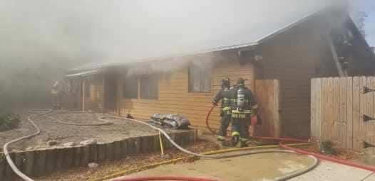 Firefighters work at a house on Baru Road on Anasasia Island in St. Augustine that caught fire on Wednesday. [CONTRIBUTED]