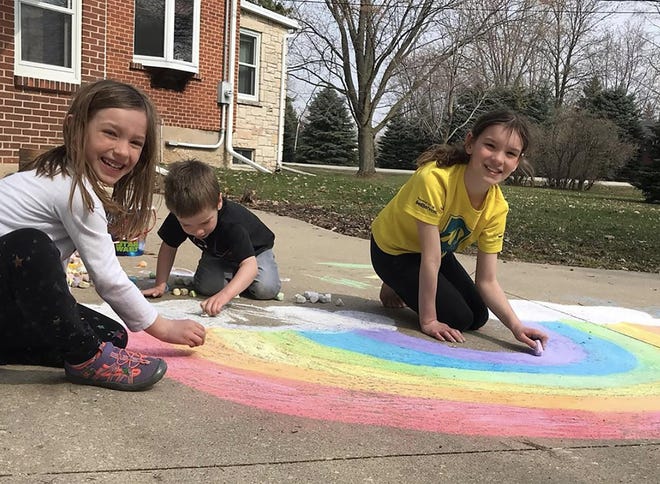 Kids work on sidewalk chalk art pictures for their local heathcare workers. [Submitted] Cindy Sharp