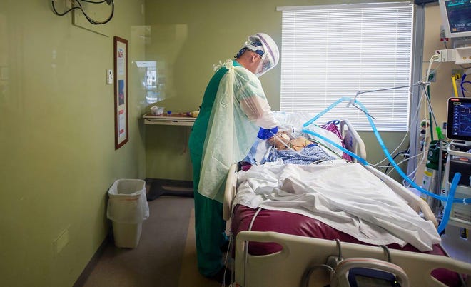 Registered nurse Robert Atchison cares for a COVID-19 patient in the intensive care unit at Gulf Coast Medical Center in Fort Myers, Florida. “We’re saving everyone we can,” Atchison said.