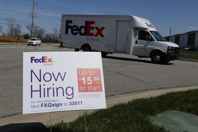 A sign advertising for jobs sits along the roadside outside a FedEx location in Zionsville, Indiana. [The Associated Press]