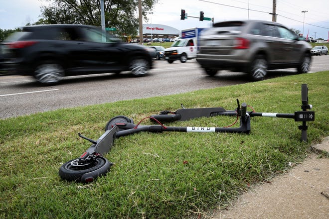 Bird scooters lay in a patch of grass outside of Hardee's on Providence Road. [Hunter Dyke/Tribune file photo]