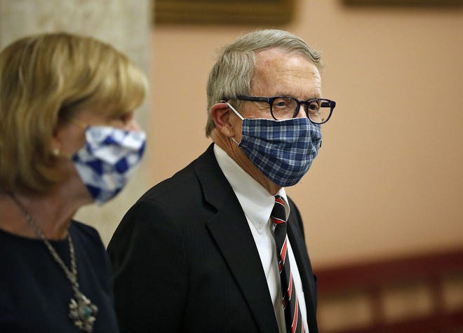 Wearing handmade masks, Ohio Gov. Mike DeWine and First Lady Fran DeWine leave the State Room after giving update on the state's response to the ongoing COVID-19 pandemic on Friday at the Ohio Statehouse in Columbus. [Kyle Robertson/Dispatch]