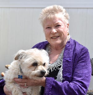 Therapist Kathy Smith-Brown, shown with her dog Russell outside her Mashpee home, is helping to coordinate free conversations with therapists for anyone who feels the need to talk during the pandemic. [Steve Heaslip/Cape Cod Times]