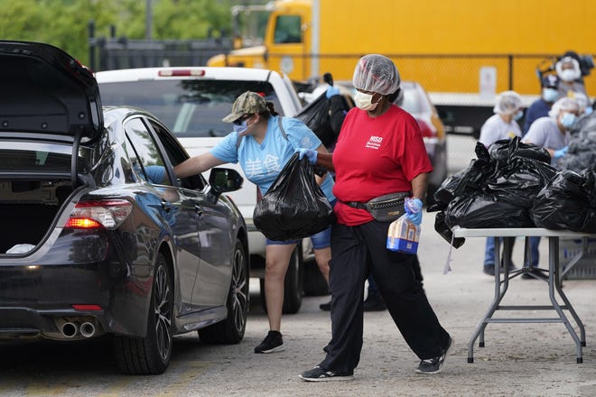 Houston Independent School District Nutrition Services staff members distribute food to families on April 6. The coronavirus pandemic exposes our differences, such as who gets free lunches at school, writes Amy Ledbetter Parham. [AP PHOTO/DAVID J. PHILLIP]