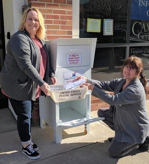 Guernsey County Board of Elections Deputy Director Marcia Metcalfe, l, and Director Lori Bamfield work together in a bi-partisan effort to gather ballots and applications from the new secure drop box outside the Guernsey County Administration Building at 627 Wheeling Ave. in downtown Cambridge.