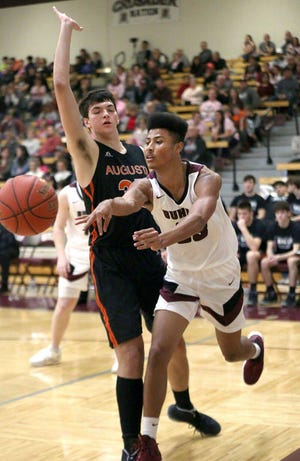 Buhler's Isaac LeShore (23) passes the ball past Augusta's Zach Davidson (35) during a game in Buhler this season. Buhler defeated Augusta 57-38. [Sandra J. Milburn/HutchNews]