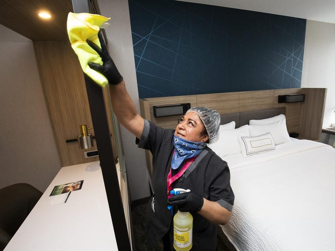 Flora Mendoza, a SpringHill Suites by Marriott Ocala housekeeper, cleans a room after returning to work on Wednesday. The hotel, owned by HDG Hotels, was approved for $2.4 million in loans as part of the Paycheck Protection Program to help continue paying workers during the COVID-19 pandemic. "Today was a good day. We brought back three housekeepers. We trained for an hour and half on the new cleaning process. We want them to feel confident and safe," hotel manager Chelewa Springs said. [Doug Engle/Staff photographer]