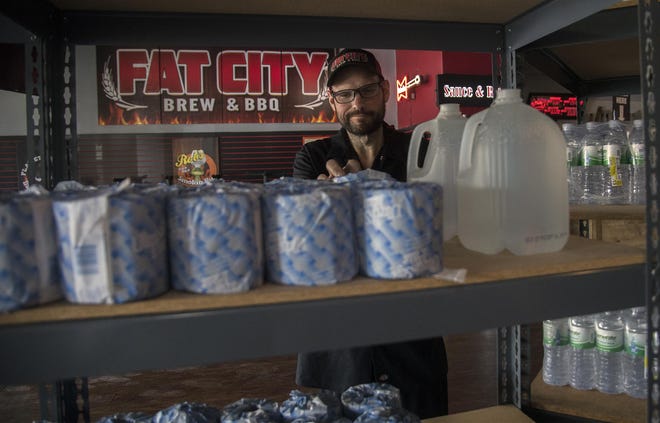 Don King, owner of Fat City BBQ on the Miracle Mile, arranges emergency items, such as toilet paper, water and latex gloves that he has for sale in addition to his barbecued foods. [CLIFFORD OTO/THE STOCKTON RECORD]