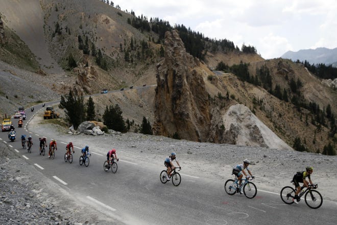 FILE - In this July 25 2019 file photo, the pack rides during the eighteenth stage of the Tour de France cycling race over 208 kilometers (130 miles) with start in Embrun and finish in Valloire, France. This year's Tour de France will now start on Aug. 29 in Nice and finish on Sept. 20 in Paris and will be followed by cycling's other two major races. The Tour could not start as scheduled on June 27 because of restrictions related to the coronavirus pandemic. (AP Photo/ Christophe Ena, File)