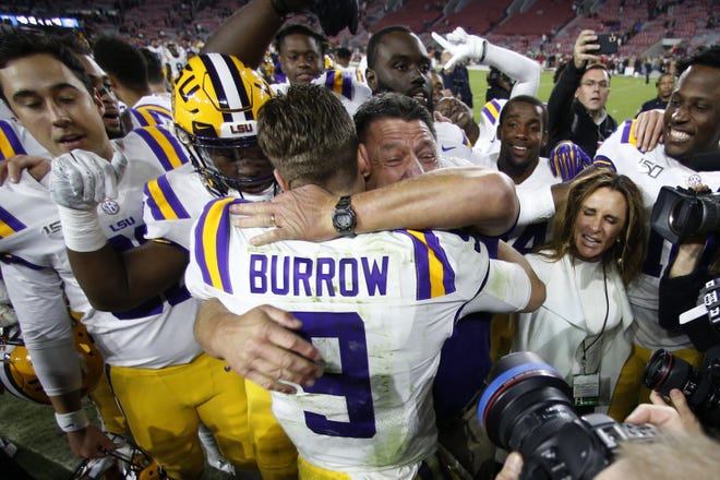 LSU head coach Ed Orgeron embraces quarterback Joe Burrow after defeating Alabama 46-41 last November in Tuscaloosa, Ala. Burrow went on to lead the Tigers to the national championship and win the Heisman Trophy, and he’s expected to be the No. 1 overall pick in next week’s NFL draft. [JOHN BLAZEMORE/THE ASSOCIATED PRESS]