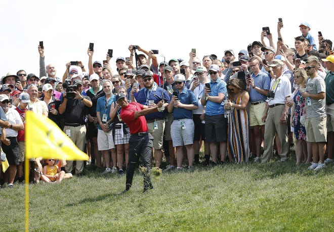Tiger Woods hits a shot in front of the gallery during the final round of the Memorial Tournament last year. Tournament director Dan Sullivan said the plan for now is to allow fans on the course if a way to do so is approved. [Adam Cairns/Dispatch]