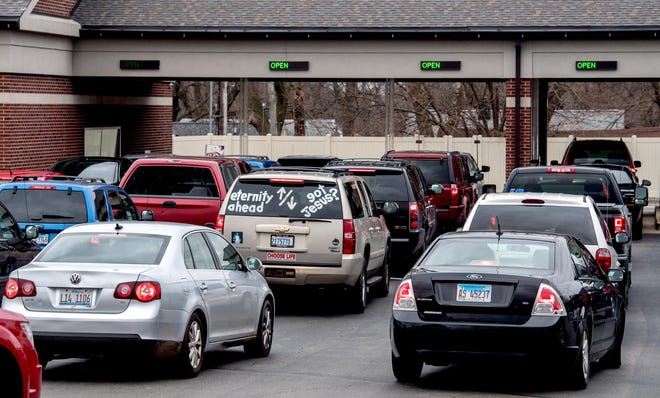 Vehicles line up to use the drive-up tellers Thursday, March 20, 2020 at the CEFCU facility on W. Lake Avenue in Peoria. CEFCU has temporarily closed its member centers until further notice, but drive-up tellers and ATMs will remain open. [MATT DAYHOFF/JOURNAL STAR]