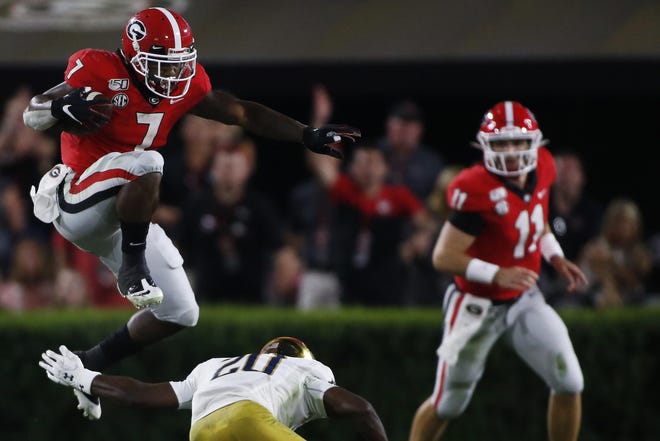 Georgia running back D'Andre Swift (7) leaps over Notre Dame corner back Shaun Crawford (20) in the second half of a NCAA football game between Georgia and Notre Dame in Athens, Ga., on Saturday, Sept. 21, 2019. Georgia won 23-17. [Photo/Joshua L. Jones, Athens Banner-Herald]