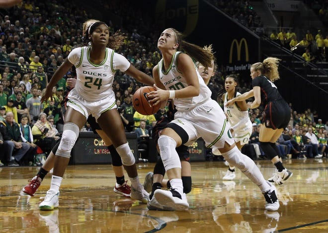 Oregon's Sabrina Ionescu drives the basket as Ruthy Hebard (24) sets a screen during the Ducks' 87-55 win over Stanford in January at Matthew Knight Arena. Ionescu was the No. 1 overall pick of the WNBA draft on Friday with Hebard the eighth selection. [Andy Nelson/The Register-Guard] - registerguard.com