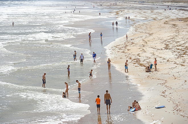 Visitors to St. Augustine Beach enjoy an afternoon in the surf before the beaches were closed due to the coronavirus pandemic. [File/The Record]