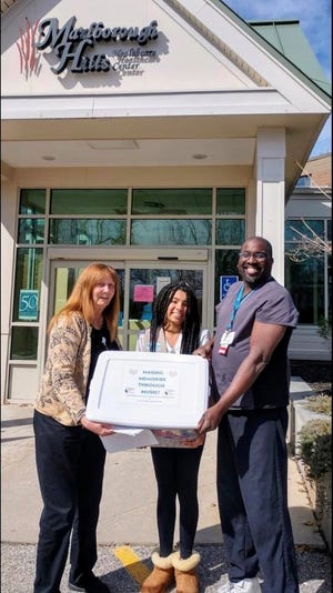 Cheyanne Houston, center, delivers the Making Memories with Music project to Marlborough Hills Rehabilitation and Health Care Center Activities Director, Linda Hogan, and her father, Carlos Houston, assistant director of nursing at the facility. [Courtesy Photo]