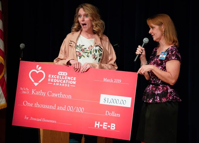 Kathy Cawthron, principal at Berkman Arts Integration Academy, receives a $1,000 check after being picked as a finalist for top elementary principal in last year’s H-E-B Excellence in Education Awards. [PHOTO COURTESY OF DARREN ABATE, H-E-B]