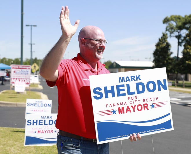 Mark Sheldon waves to voters on Tuesday at Frank Brown Park. [PATTI BLAKE/THE NEWS HERALD]