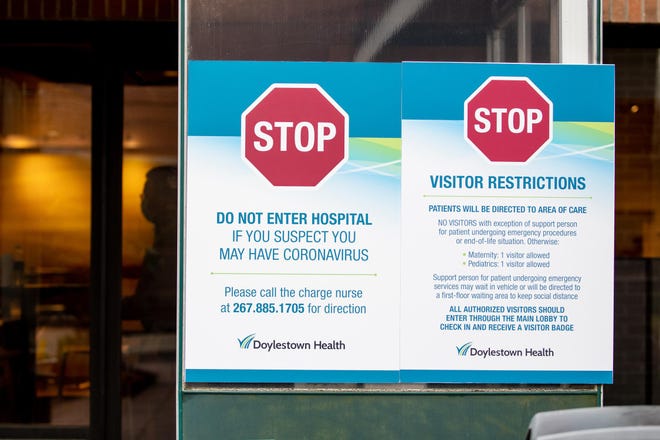File - A sign posted outside an entrance to Doylestown Health on Monday, March 30, 2020, details the hospital's visitor restrictions implemented during the coronavirus COVID-19 pandemic. [MICHELE HADDON / PHOTOJOURNALIST]