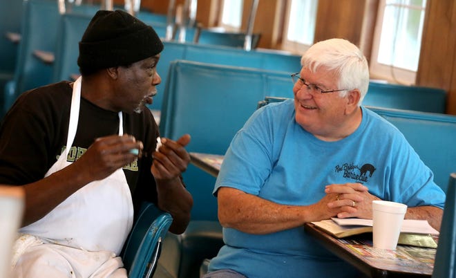 Jerry Nicholson and Doug Bridges chat about scripture at a Thursday morning worship session at Red Bridges Barbecue. [Brittany Randolph/The Star]