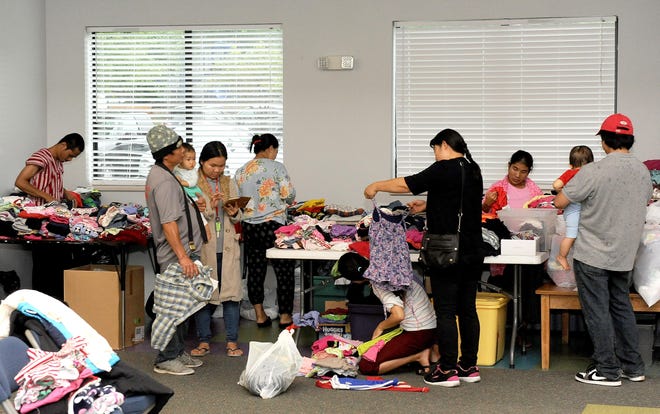 Families look over free clothing at City of Refuge in Columbia. Refugee resettlements in Columbia have halted as a result of the COVID-19 pandemic. [Don Shrubshell/Tribune file photo]