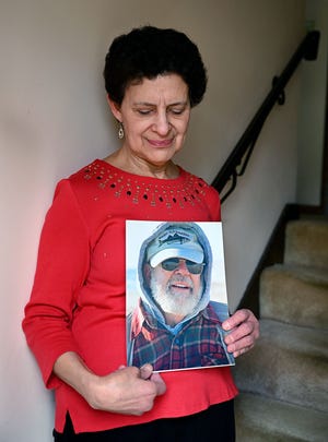 Sheila Courchaine of Marlborough holds a photograph of her late husband Armand Courchaine, 76, who died April 14 after a more than two-week long battle with the coronavirus. Armand was a U.S. Navy veteran and a lifelong fly fisherman. Sheila herself tested positive and has recovered from the virus.

 [Daily News and Wicked Local Staff Photo/Ken McGagh]