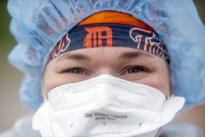 Corrine Jachim, a registered medical assisant from Flushing, wears her mother's Detroit Tigers cap as she works to test the first 50 people for coronavirus at Flint's first drive-thru testing site on Monday, April 15, 2020 at Atwood Stadium in Flint. (Jake May | MLive.com) The Flint Journal, MLive.com